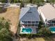 Aerial view of backyard pool of a two-story home, showcasing the backyard lounge and patio with a golf course view at 7419 Gathering Ct, Reunion, FL 34747