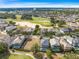 Aerial view of a residential area near a golf course, displaying multiple homes and well-maintained greenery at 7419 Gathering Ct, Reunion, FL 34747