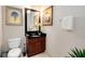 Cozy bathroom featuring toilet, single vanity with black countertop, and palm artwork at 7419 Gathering Ct, Reunion, FL 34747