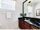 Bright bathroom featuring dark wood cabinets, white counters, and a modern vessel sink at 7419 Gathering Ct, Reunion, FL 34747