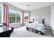 Cozy bedroom with large windows, light gray walls, and colorful floral bedding at 7419 Gathering Ct, Reunion, FL 34747