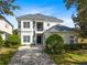 Beautiful two-story home with lush landscaping, a paved driveway, and a charming front porch with a balcony at 7419 Gathering Ct, Reunion, FL 34747