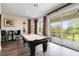 Bright game room with a billiards table, bar seating, and a sliding glass door leading to the outdoor area at 7419 Gathering Ct, Reunion, FL 34747