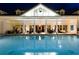 Night shot of an illuminated pool with views of the clubhouse and outdoor seating at 7419 Gathering Ct, Reunion, FL 34747