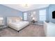 Light and airy primary bedroom featuring soft blue walls, plush carpet, and a cozy seating area at 830 Sticks, Davenport, FL 33896