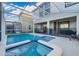 Beautiful pool and spa in a screened enclosure, with a view of the home's back exterior at 830 Sticks, Davenport, FL 33896