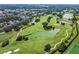 Aerial view of a lush golf course with multiple ponds and surrounding residences at 906 Blue Sage St, Kissimmee, FL 34747