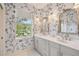 Bathroom with double sinks, stylish wallpaper with decorative floral design, and a large window at 906 Blue Sage St, Kissimmee, FL 34747