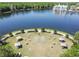 Aerial view of an outdoor wedding ceremony site on a grassy lawn by a lake and mature trees at 906 Blue Sage St, Kissimmee, FL 34747