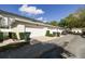 Exterior view of a row of townhome garages, well maintained landscaping, and ample parking space at 906 Blue Sage St, Kissimmee, FL 34747