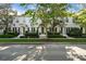 Attractive townhouse exteriors with black shutters are framed by mature trees and manicured greenery along a paved street at 906 Blue Sage St, Kissimmee, FL 34747