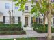 Charming townhome featuring manicured landscaping, a columned front porch, and elegant black window shutters at 906 Blue Sage St, Kissimmee, FL 34747