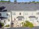 Rear aerial view of a white two story townhouse with a well maintained roof and a brick courtyard at 906 Blue Sage St, Kissimmee, FL 34747