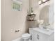 Bright half bathroom with floating wood shelves above toilet, white vanity, and modern fixtures at 9149 Grand Island Way, Winter Garden, FL 34787