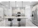 Modern kitchen island with white cabinets, granite countertops, and barstool seating at 9149 Grand Island Way, Winter Garden, FL 34787