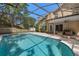 A screened pool with covered patio seating provides a relaxing backyard oasis at 936 Summer Lakes Dr, Orlando, FL 32835