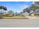 Inviting single-story home with a white exterior, set in a neighborhood with mature trees and blue sky backdrop at 1022 Glenharbor Cir, Winter Garden, FL 34787