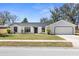 Charming single-story home with a fresh white exterior, black trim, and a well-manicured front yard at 1022 Glenharbor Cir, Winter Garden, FL 34787