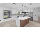 Well-lit kitchen featuring modern appliances, white cabinets, mosaic backsplash, and a stylish island, adjacent to living area at 1022 Glenharbor Cir, Winter Garden, FL 34787