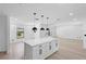 Stylish kitchen island with a quartz countertop and pendant lighting, connected to a bright and open living area at 1022 Glenharbor Cir, Winter Garden, FL 34787