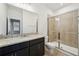 Bathroom showcasing granite countertops, dark cabinets, and a modern glass-enclosed shower at 1210 Normandy Dr, Haines City, FL 33844