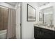 Bathroom featuring a black vanity, granite countertop, decorative mirror, and tiled shower at 1210 Normandy Dr, Haines City, FL 33844