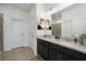 Bathroom with double sinks, granite counters, dark cabinetry, and framed wall art at 1210 Normandy Dr, Haines City, FL 33844