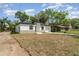 Exterior view of the home with a white exterior and neatly cut grass at 1215 Crawford Ave, St Cloud, FL 34769