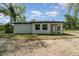 Side exterior view of the home featuring a white exterior and dark roof at 1215 Crawford Ave, St Cloud, FL 34769