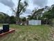 Spacious backyard featuring a large tree, shed, and ample green space at 1246 Rhodes Ct, Orlando, FL 32808