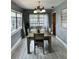 Elegant dining room featuring a modern table, stylish lighting, and serene gray walls complemented by wood-look floors at 1246 Rhodes Ct, Orlando, FL 32808