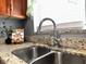 Kitchen featuring stainless steel fixtures, including a modern faucet, set against granite countertops and wood cabinetry at 1246 Rhodes Ct, Orlando, FL 32808