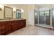 Bathroom featuring double sinks, granite countertops, and a glass-enclosed walk-in shower at 1601 Carillon Park Dr, Oviedo, FL 32765