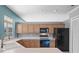 Well-lit kitchen featuring wood cabinets, modern black appliances, and a bright white countertop at 1601 Carillon Park Dr, Oviedo, FL 32765