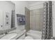 Well-lit bathroom featuring a shower-tub combo with gray tiling and granite countertops at 1718 Blue Lagoon Cir, Mascotte, FL 34753