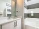 Bright bathroom featuring a shower-tub combo and a vanity with a marble countertop, enhanced by elegant chrome fixtures at 1739 Oak Blossom Dr, Davenport, FL 33837