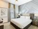 Modern bedroom featuring a decorative gray accent wall, ceiling fan, and neutral-toned furnishings at 1739 Oak Blossom Dr, Davenport, FL 33837