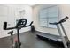 Bright home gym featuring modern equipment like a treadmill and stationary bike, plus large windows at 1739 Oak Blossom Dr, Davenport, FL 33837