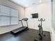 Well-equipped exercise room with a treadmill, stationary bike, and mounted TV for at-home workouts at 1739 Oak Blossom Dr, Davenport, FL 33837