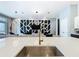 Modern kitchen island with sink, faucet, and open view to the living room with decorative wall at 1739 Oak Blossom Dr, Davenport, FL 33837