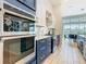 Modern kitchen with white subway tile, quartz countertops, stainless steel appliances, and navy blue cabinets at 1739 Oak Blossom Dr, Davenport, FL 33837