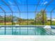 The screened-in pool area offers a basketball hoop, waterslide, and peaceful views at 1739 Oak Blossom Dr, Davenport, FL 33837