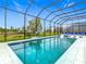 A beautiful, enclosed pool offers hours of enjoyment with chairs and outside view at 1739 Oak Blossom Dr, Davenport, FL 33837