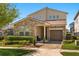 Charming two-story home showcasing a stone facade, well-manicured lawn, and a welcoming, covered entryway at 1832 Sandy Park Trl, Kissimmee, FL 34747