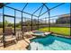 Relaxing in-ground spa with screened enclosure, brick paver decking, and lounge chairs by the pool at 1832 Sandy Park Trl, Kissimmee, FL 34747