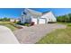 Side view of a two-story home with white siding and a paver driveway at 2055 Quiet Cv, Sanford, FL 32771