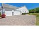 Spacious three-car garage features a paver driveway and well-maintained landscaping at 2055 Quiet Cv, Sanford, FL 32771