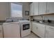 Laundry room features side by side washer and dryer, plus basin, and custom cabinets at 2055 Quiet Cv, Sanford, FL 32771