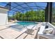 Relaxing screened pool area with comfortable lounge seating and a view of the lush backyard at 2055 Quiet Cv, Sanford, FL 32771