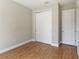 Bedroom featuring wood flooring, a closet with white sliding doors, and white trim at 2341 Oleander Rd, Deland, FL 32724